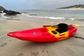 The Feelfree Nomad Sport shown in Red/Yellow/Red at the beach