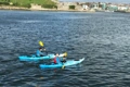 A pair of kayakers paddling the Riot Enduro kayaks in coastal waters